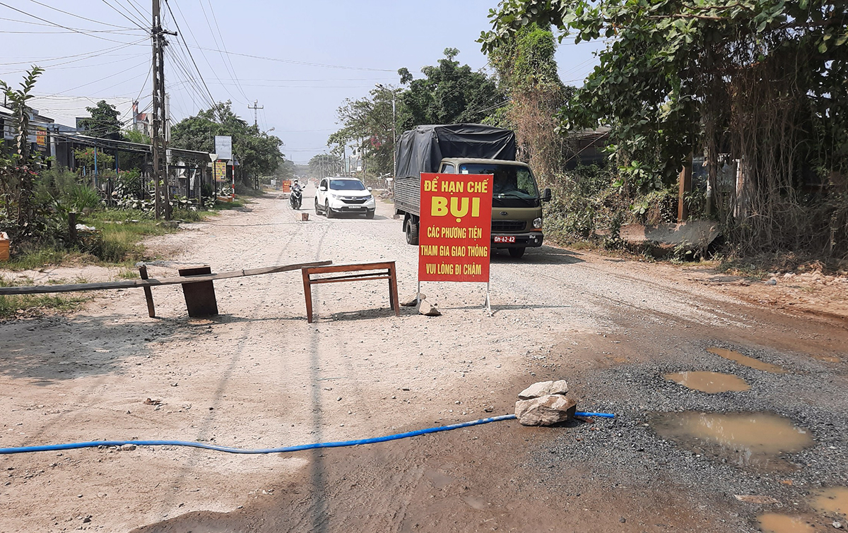 Người dân dùng nhiều đồ vật rào chắn ngăn xe chạy nhanh gây bụi. Ảnh: Sơn Thủy