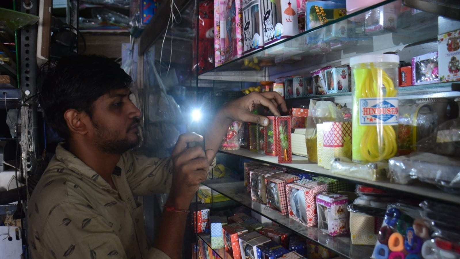 mumbai-1864-1686236509 Chủ một cửa hàng ở Thane (Ấn Độ) dùng điện thoại soi đèn khi mất điện. Ảnh: Hindustan Times