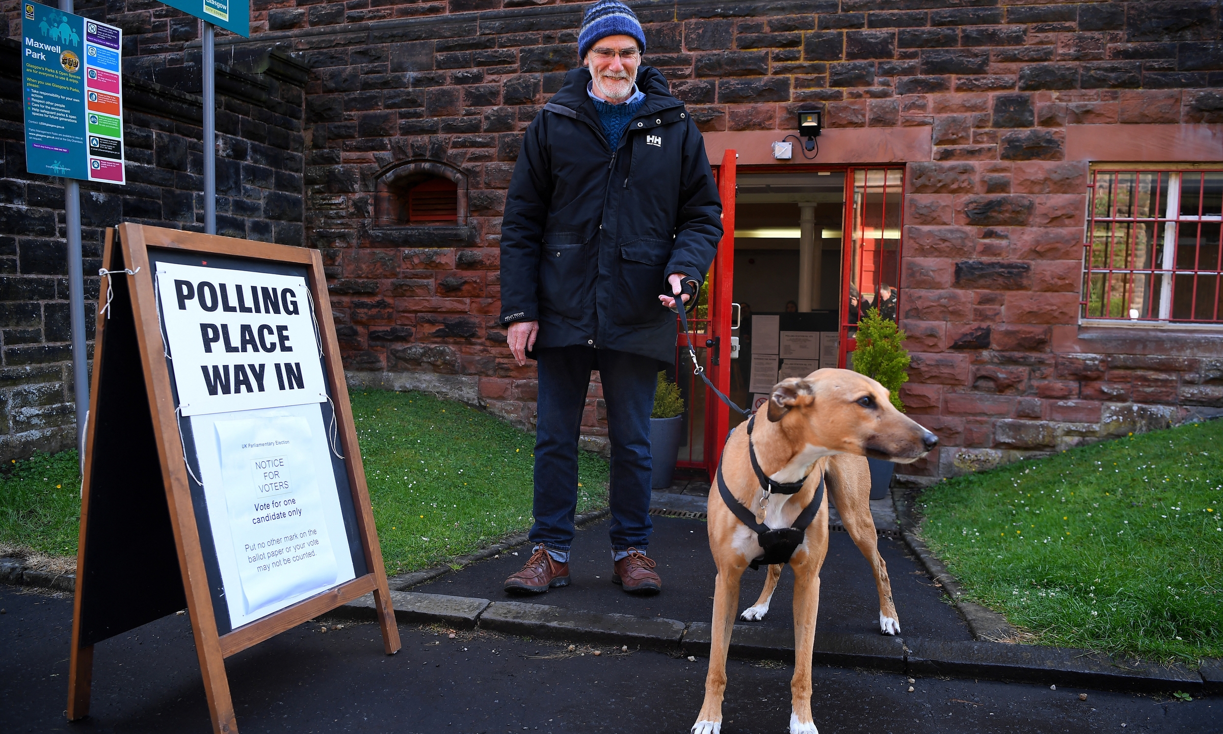 Cử tri dắt chó tới điểm bỏ phiếu ở Glasgow, Anh, ngày 4/7. Ảnh: AFP