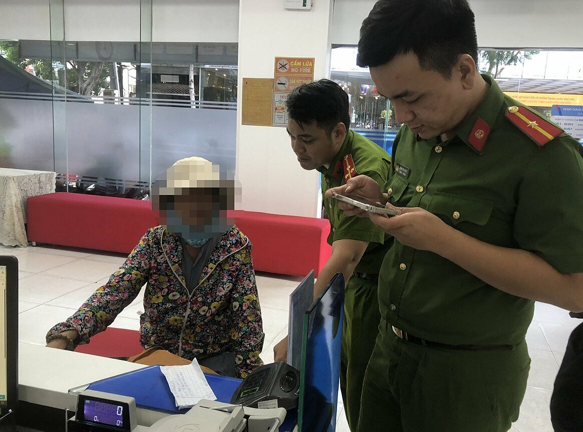 Công an giải thích cho người phụ nữ để không chuyển tiền cho kẻ lừa đảo. Ảnh: Công an cung cấp