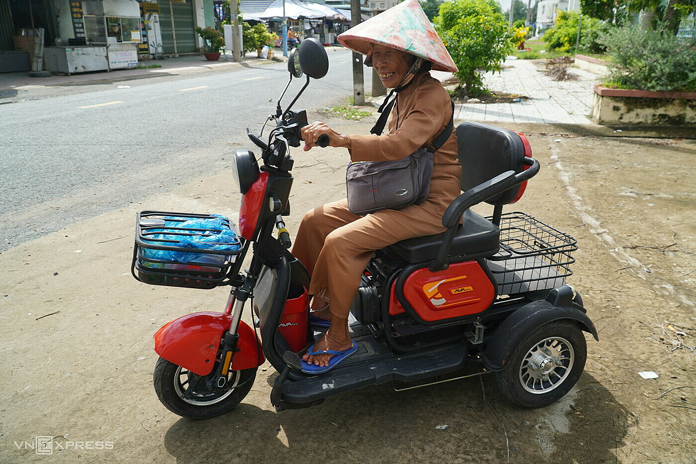 Bà Bảy trên chiếc xe điện ba bánh, ngày ngày bán vé số dạo ở chợ Nước Xoáy, xã Long Hưng A, huyện Lấp Vò. Ảnh: Ngọc Tài