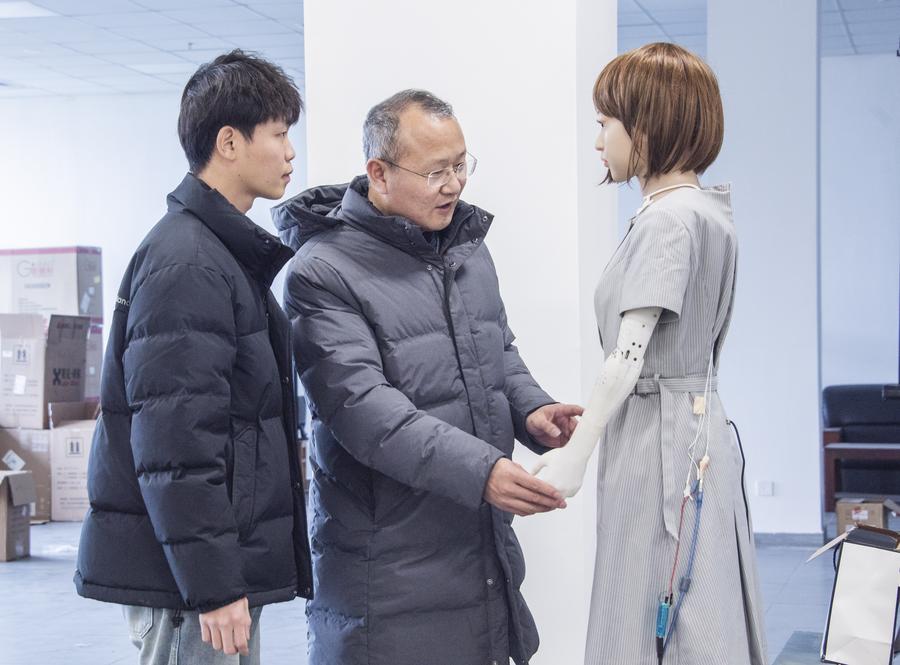 Giáo sư Liu Xiaofeng nói chuyện với một nghiên cứu sinh về robot hình người tại Đại học Hà Hải. Ảnh: Xinhua