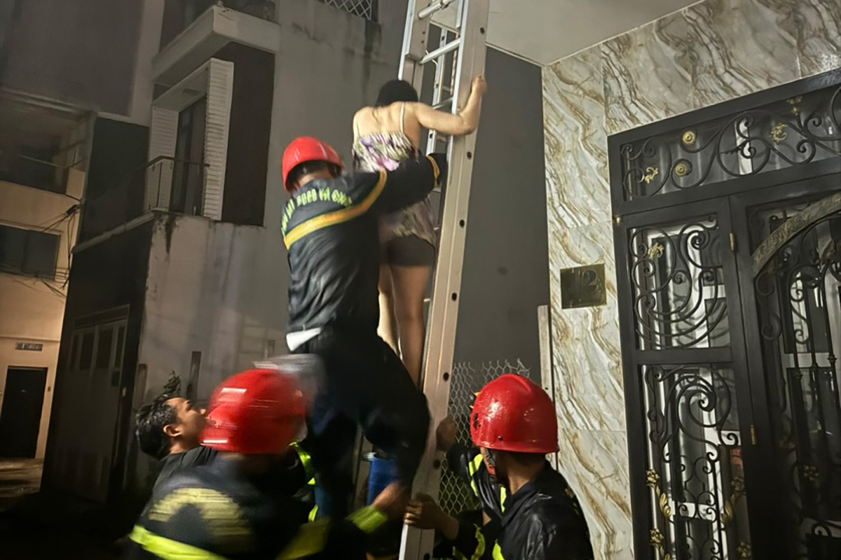 Cảnh sát dùng thang đưa một phụ nữ xuống đất. Ảnh: Công an Bà Rịa - Vũng Tàu cung cấp