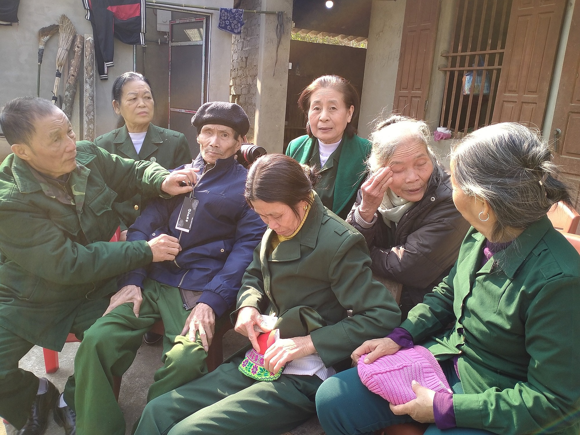 Ông Hoàng Văn Thắng (áo xanh đen, đội mũ), bà Bùi Thị Loan (ngồi cạnh bên phải ông Thắng) ở huyện Chợ Đồn, tỉnh Bắc Kạn được các đồng đội ở Thái Nguyên lên thăm, năm 2022. Ảnh: Trần Thị Hoài