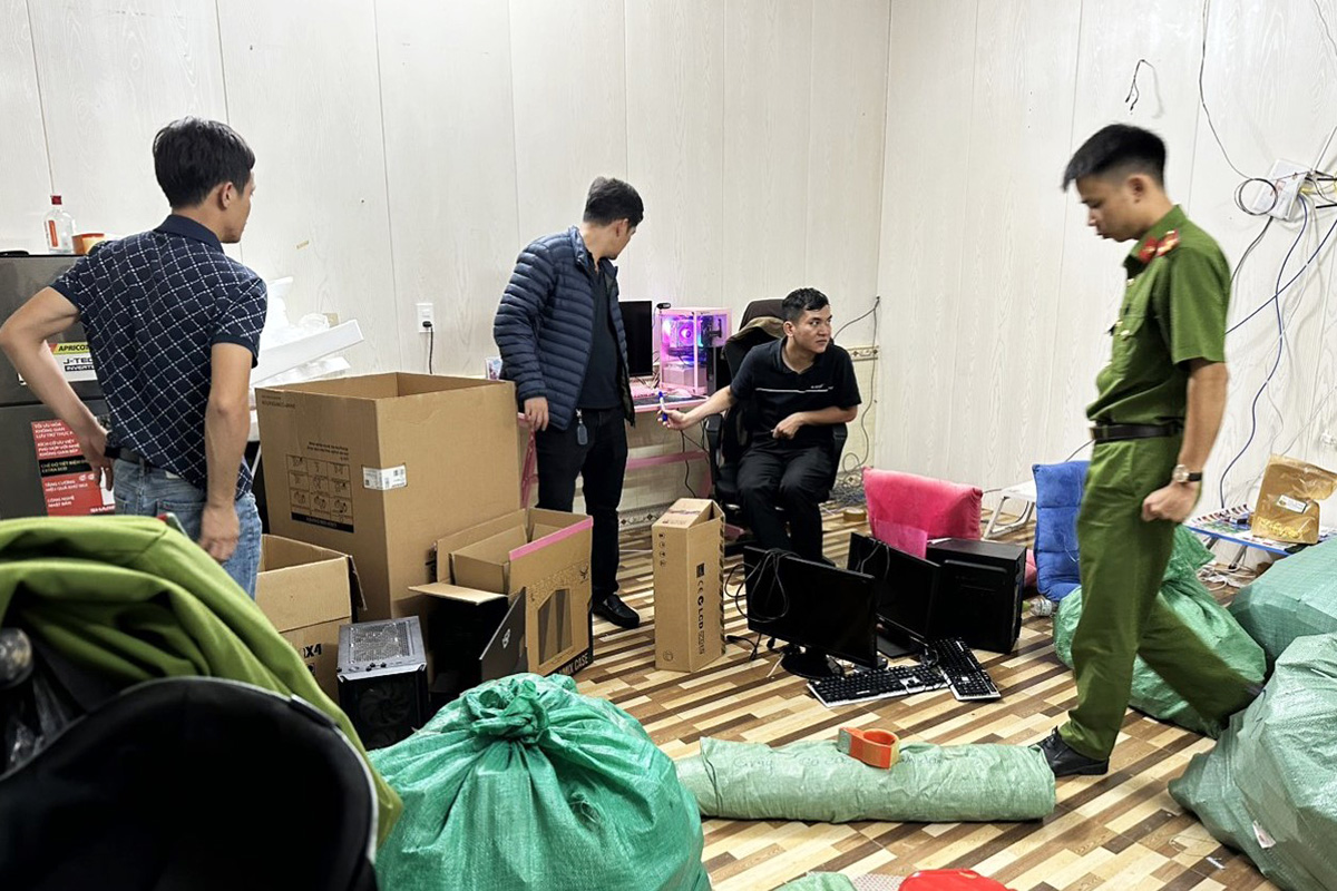 Cảnh sát khám xét một ngôi nhà ở TP Bảo Lộc thu giữ nhiều máy tính, tiền âm phủ. Ảnh: Hoài Thanh