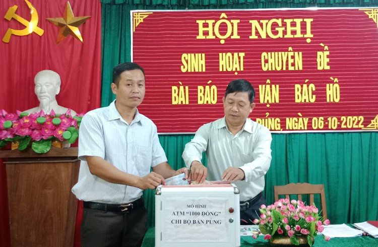 Cán bộ ở huyện Tương Dương góp tiền vào cây ATM 1.000 đồng. Ảnh: Hùng Lê