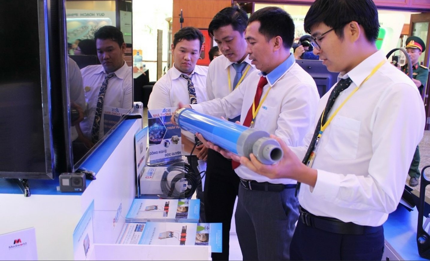Kỹ sư Lê Trung Hiếu (giữa) giới thiệu sản phẩm xử lý cáu cặn trên ống nước ở một triển lãm tại TP HCM năm 2020. Ảnh: NVCC