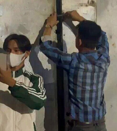 Đào Chí Tâm (áo sọc) khóa cửa nhốt hai thành viên đoàn kiểm tra. Ảnh: An Minh