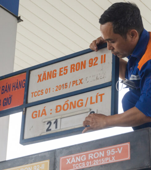 Nhân viên một cây xăng thay bảng niêm yết giá sau quyết định điều chỉnh giá bán của cơ quan quản lý. Ảnh: Quỳnh Trần