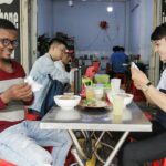 Thầy Nadis (trái) thưởng thức bún riêu cùng bạn tại TPHCM, ngày 19/3. Ảnh nhân vật cung cấp