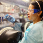 TS Phụng làm việc trong buồng chân không, trong quy trình lắp ráp pin cúc áo. Ảnh: NVCC