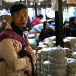 Một người đàn ông địu con bán hàng tại chợ ở Thimpu, thủ đô Bhutan, hồi tháng 1. Ảnh: AFP
