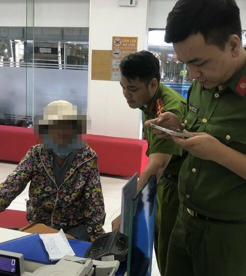 Công an giải thích cho người phụ nữ để không chuyển tiền cho kẻ lừa đảo. Ảnh: Công an cung cấp