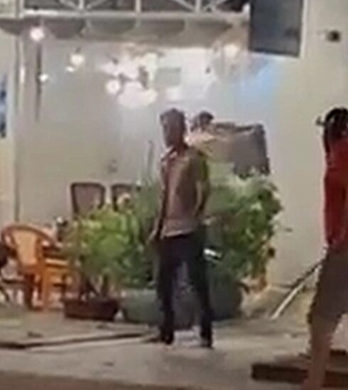 Trần Văn Ty (áo đỏ) thời điểm mang dao đi chém con nợ. Ảnh: An Minh