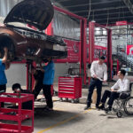 Nguyễn Ngọc Hà trao đổi công việc cùng đồng nghiệp tại gara sửa chữa ô tô do anh làm giám đốc. Ảnh: Diệp Phan