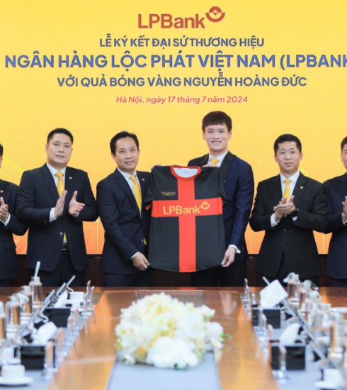 Ông Lê Minh Tâm, Phó chủ tịch thường trực Hội đồng quản trị LPBank (trái) trao trang phục cho cầu thủ Hoàng Đức tại lễ công bố đại sứ thương hiệu Ngân hàng Lộc Phát Việt Nam (phải). Ảnh: LPBank