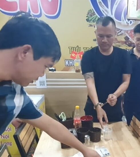 Huy (đeo còng tay) khi bị bắt. Ảnh Công an cung cấp