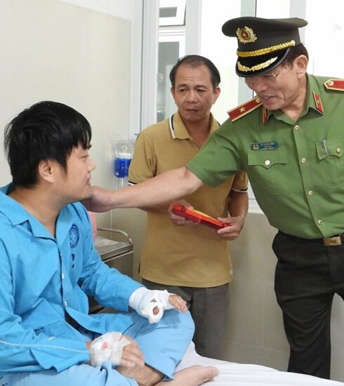 Một trong hai cán bộ công an bị Sách tấn công, bị thương ở tay được Giám đốc Công an TP Đà Nẵng thăm hỏi, động viên. Ảnh: Văn Hồ