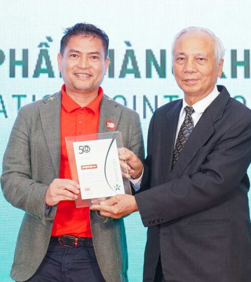 Ông Nguyễn An Di - Giám đốc Nhân sự Vietjet (áo T - shirt đỏ, áo khoác ghi xám) nhận giải thưởng tôn vinh Top 50 doanh nghiệp phát triển bền vững từ ban tổ chức