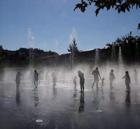 Người dân giải nhiệt bên dưới đài phun nước ở công viên Madrid Rio tại Madrid, Tây Ban Nha, hôm 23/7. Ảnh: AFP