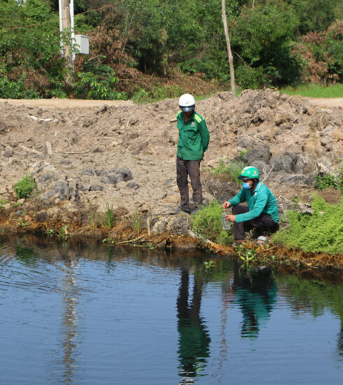 Lực lượng chức năng lấy mẫu nước dưới dòng kênh bị ô nhiễm do nhà máy phân bón công ty xả thải hồi tháng 6. Ảnh: Nam An
