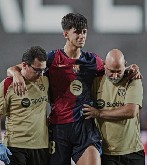 Bernal (giữa) được dìu rời sân cuối trận Rayo - Barca tối 27/8. Ảnh: EFE