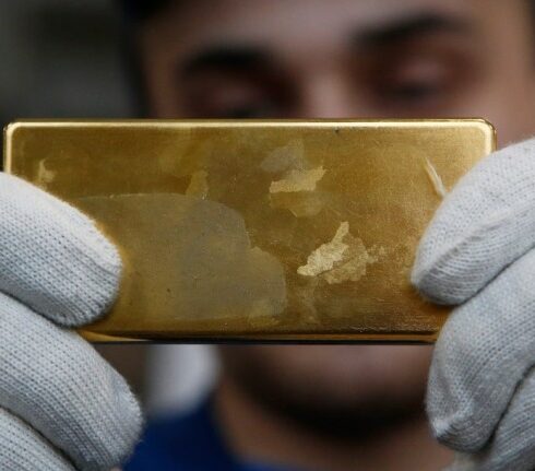 Nhân viên cầm thỏi vàng tại nhà máy ở Kasimov (Nga). Ảnh: Reuters