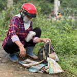 Người thân bên cặp sách còn sót lại của học trò Làng Nủ sau trận lũ quét rạng sáng 10/9. Ảnh: Hoàng Phương