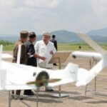 Ông Kim Jong-un bên cạnh hai mẫu UAV tự sát trong chuyến thăm hôm 24/8. Ảnh: KCNA