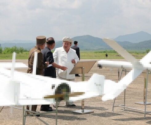 Ông Kim Jong-un bên cạnh hai mẫu UAV tự sát trong chuyến thăm hôm 24/8. Ảnh: KCNA