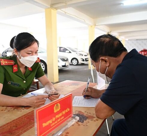 Cán bộ công an xã ở Hà Nội hướng dẫn người dân làm thủ tục cấp biển số xe máy. Ảnh: Gia Chính